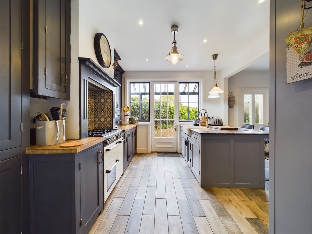 Handmade bespoke kitchen with shaker-style cabinets, oak worktops and brass pendant lighting