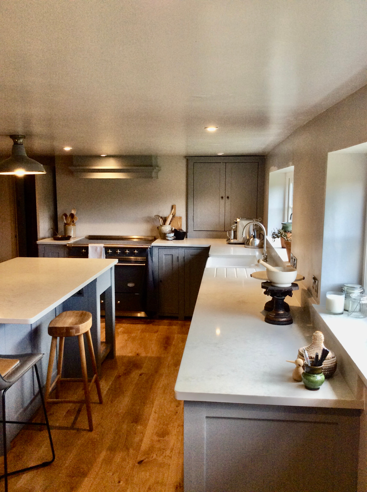Handmade shaker kitchen in grey with a central island, stone worktops and range cooker
